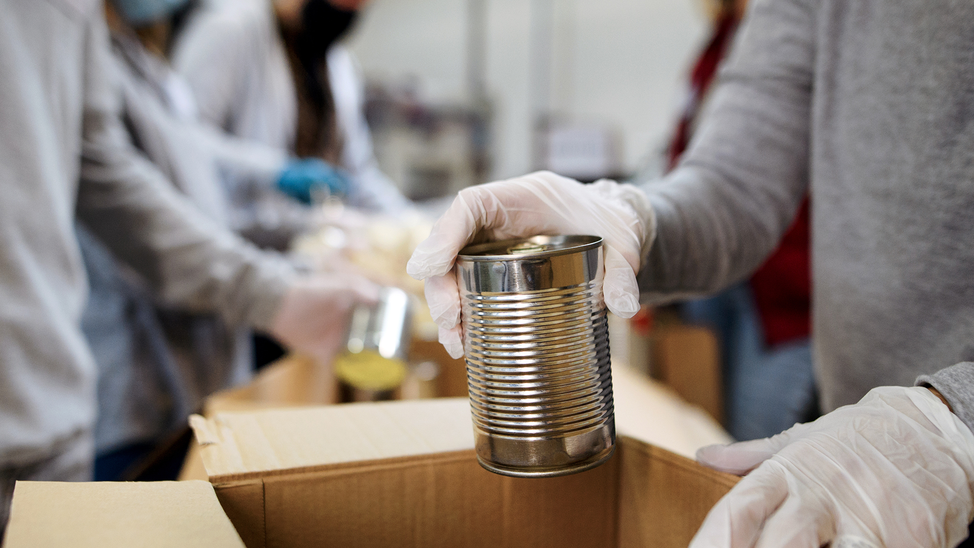 Volunteer placing canned good in a box.